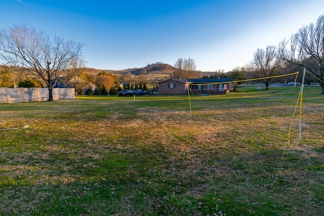 view of yard with volleyball court, fence, and a mountain view