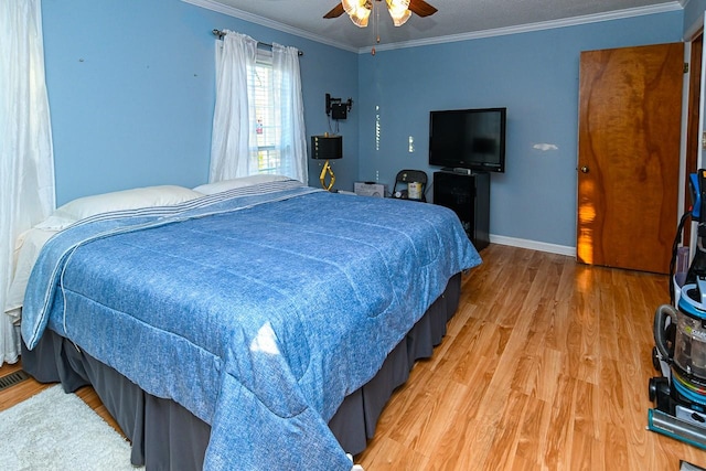 bedroom featuring ornamental molding, a ceiling fan, light wood-style flooring, and baseboards