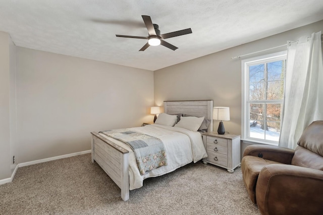 bedroom with a ceiling fan, light carpet, a textured ceiling, and baseboards