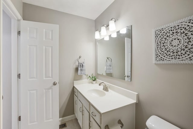 half bath featuring visible vents, baseboards, toilet, tile patterned flooring, and vanity