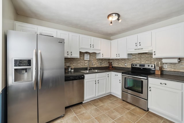 kitchen with tasteful backsplash, dark countertops, appliances with stainless steel finishes, under cabinet range hood, and a sink