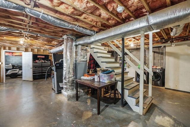 unfinished basement featuring washer / clothes dryer, stairway, and concrete block wall