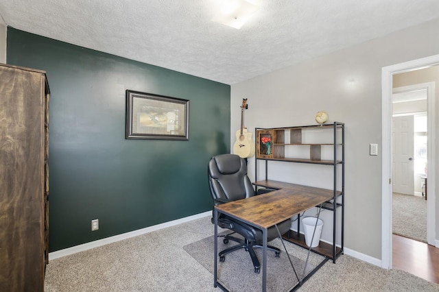 office area featuring carpet, baseboards, and a textured ceiling