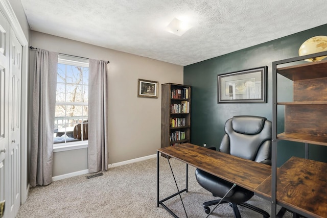 office area with carpet floors, a textured ceiling, and baseboards