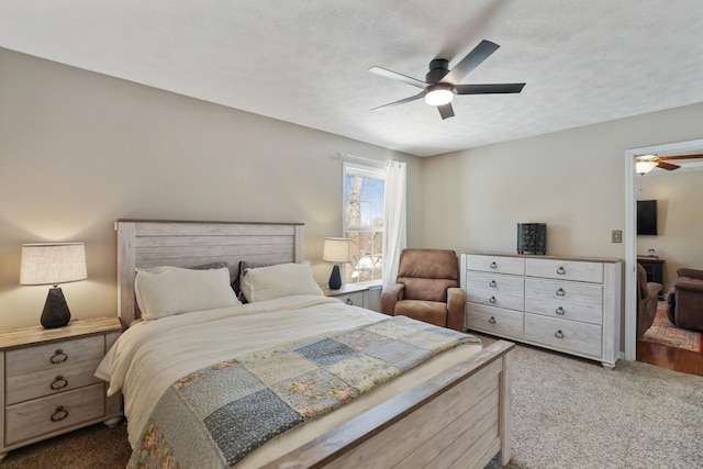 carpeted bedroom with a textured ceiling and ceiling fan