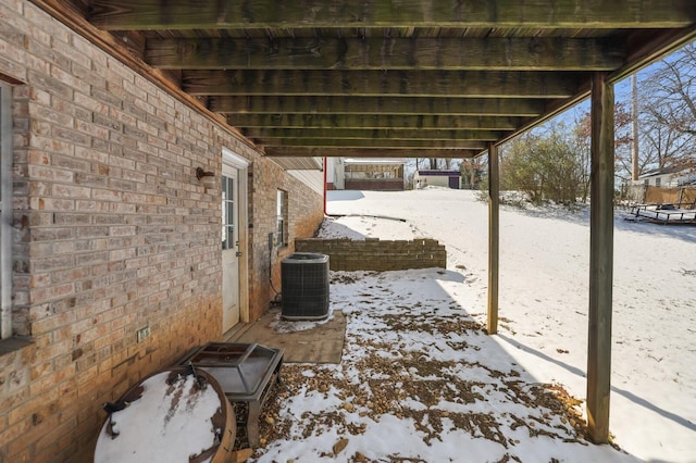 snow covered patio with cooling unit