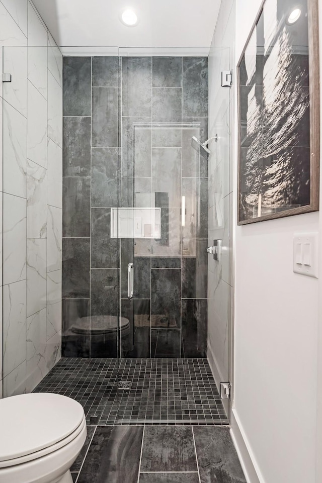 bathroom featuring a shower stall and toilet