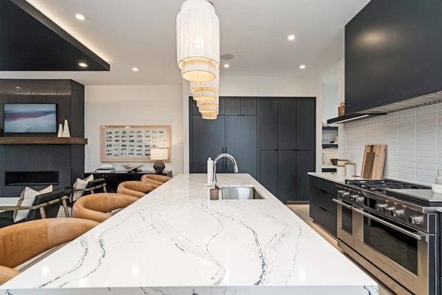 kitchen with a spacious island, a large fireplace, a sink, modern cabinets, and double oven range