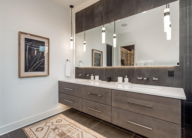 bathroom featuring double vanity, a sink, backsplash, and tile patterned floors