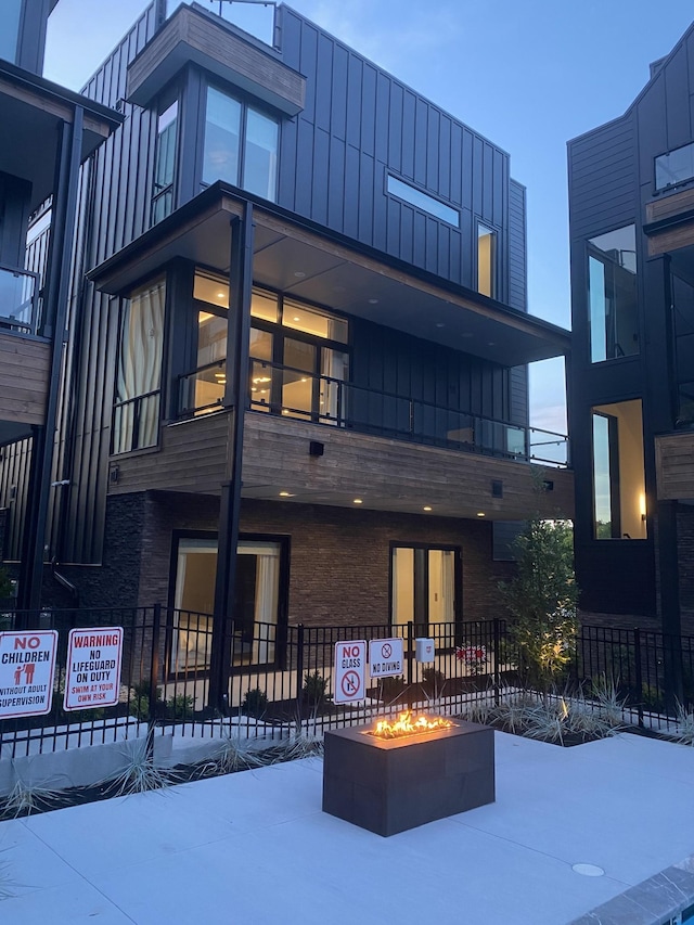 exterior space with a fire pit and board and batten siding