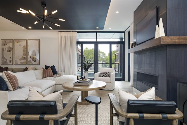 living area featuring a fireplace, floor to ceiling windows, a chandelier, and recessed lighting