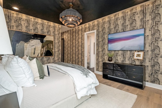 bedroom with wallpapered walls, baseboards, and wood finished floors