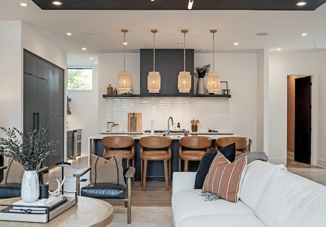 living area featuring light wood-type flooring, baseboards, and recessed lighting