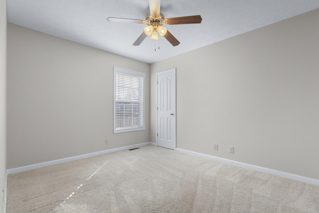 carpeted spare room with baseboards and a ceiling fan