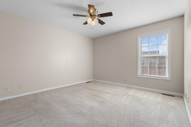 unfurnished room featuring visible vents, baseboards, ceiling fan, and carpet floors