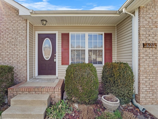 doorway to property with brick siding