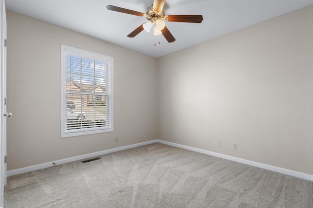 carpeted empty room featuring visible vents, baseboards, and ceiling fan