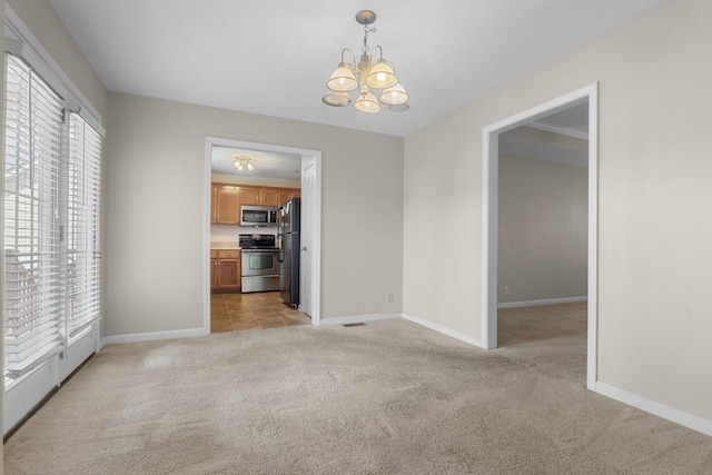 unfurnished room featuring light carpet, a notable chandelier, and baseboards