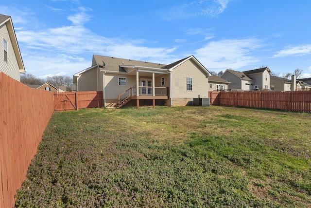 rear view of house featuring a fenced backyard and a yard