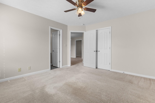 unfurnished bedroom with carpet, baseboards, a closet, and ceiling fan