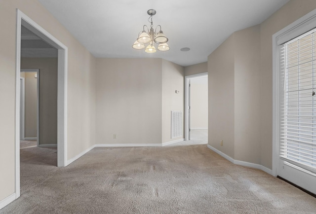 unfurnished room with carpet flooring, baseboards, visible vents, and a chandelier