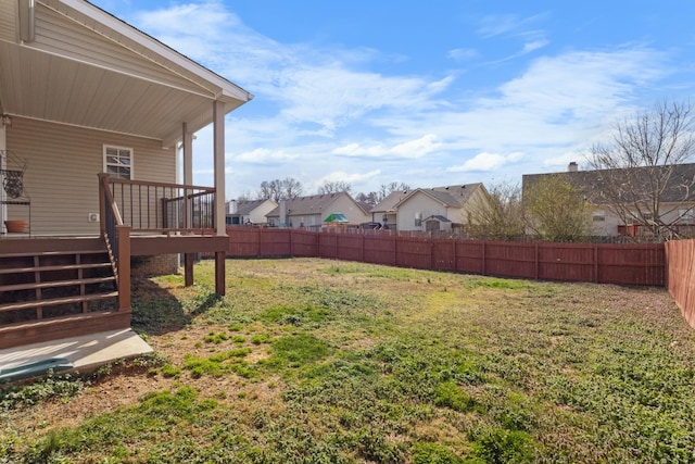 view of yard featuring fence, a residential view, and a wooden deck