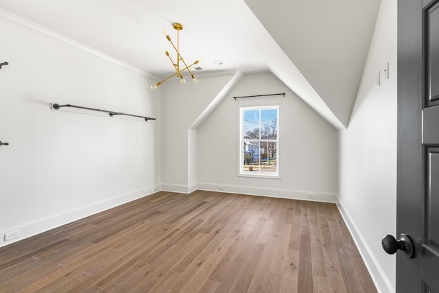 bonus room featuring a notable chandelier, baseboards, vaulted ceiling, and wood finished floors