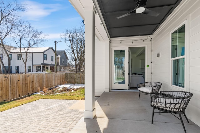 view of patio / terrace with a residential view, fence, and ceiling fan