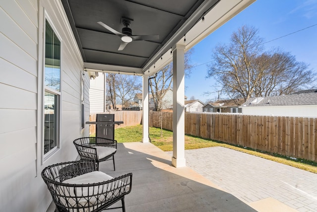 view of patio with a grill, fence, and a ceiling fan