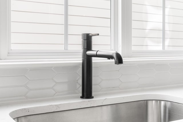 interior details with light stone counters, a sink, and log walls