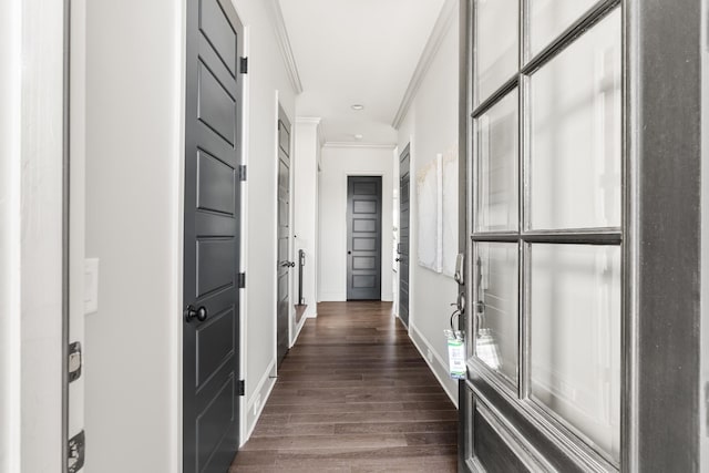 hall featuring ornamental molding, dark wood-type flooring, and baseboards