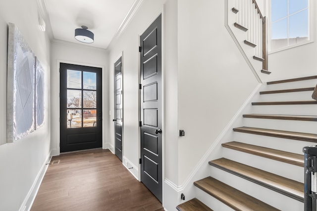 doorway with stairway, baseboards, ornamental molding, and wood finished floors