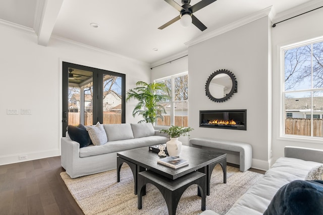 living area with ornamental molding, wood finished floors, and a wealth of natural light