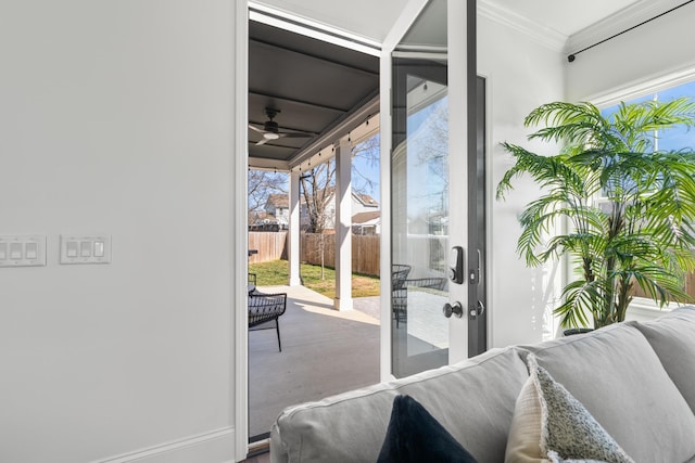 doorway to outside featuring ceiling fan and ornamental molding