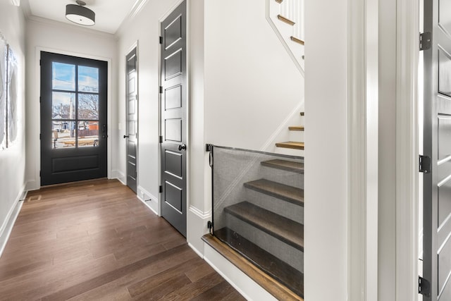 doorway to outside with dark wood-type flooring, ornamental molding, baseboards, and stairs