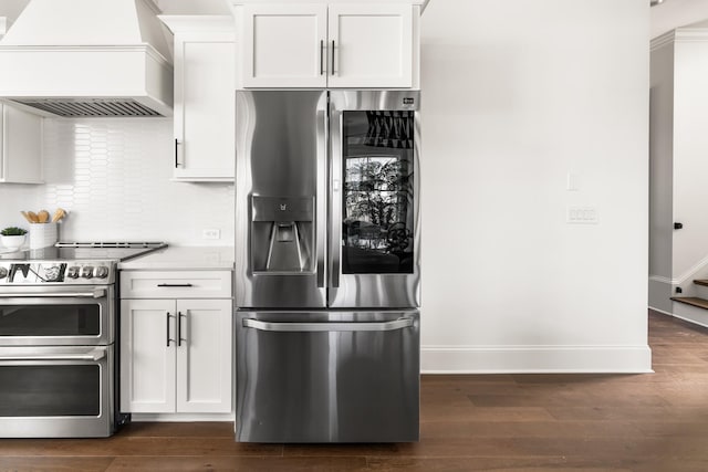 kitchen with baseboards, dark wood-style floors, appliances with stainless steel finishes, light countertops, and premium range hood