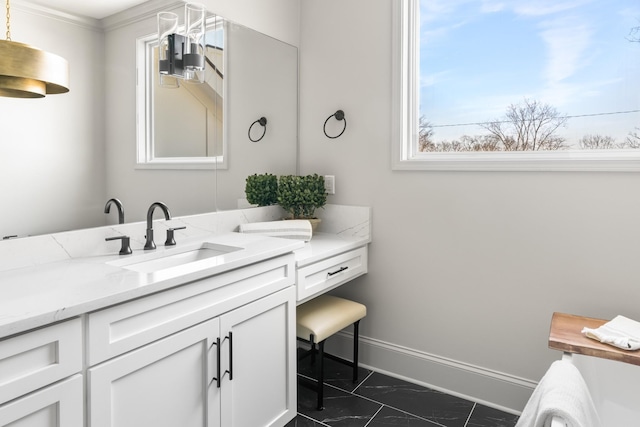 bathroom with marble finish floor, vanity, and baseboards