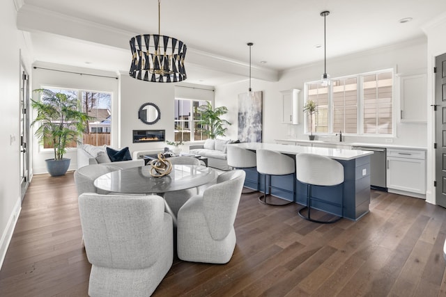 dining space with recessed lighting, crown molding, dark wood-type flooring, and a glass covered fireplace