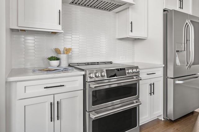 kitchen with stainless steel appliances, range hood, white cabinetry, and tasteful backsplash