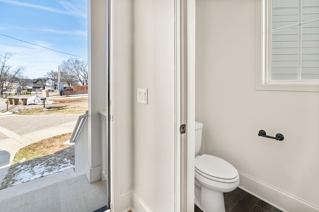 bathroom featuring wood finished floors, toilet, and baseboards