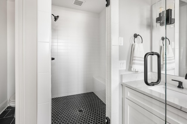 bathroom with visible vents, toilet, a stall shower, vanity, and tile patterned floors