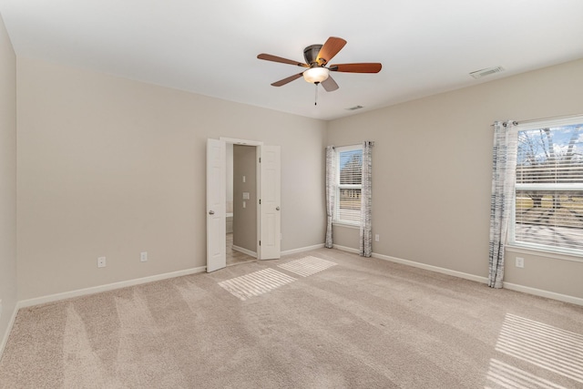 unfurnished room featuring light carpet, ceiling fan, visible vents, and baseboards