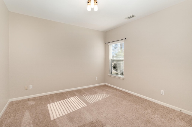 unfurnished room with carpet flooring, visible vents, and baseboards