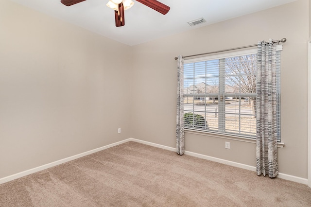 unfurnished room featuring light carpet, visible vents, baseboards, and a ceiling fan