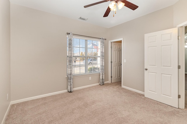 unfurnished bedroom featuring light carpet, ceiling fan, visible vents, and baseboards