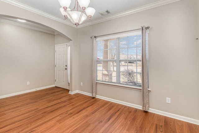 unfurnished room with arched walkways, visible vents, a notable chandelier, and light wood finished floors