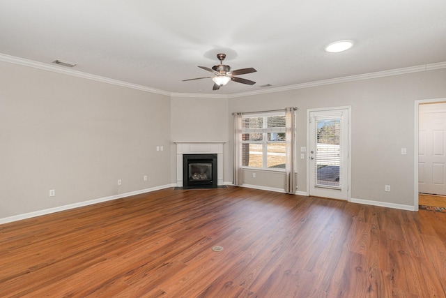 unfurnished living room with ornamental molding, visible vents, a fireplace with flush hearth, and wood finished floors