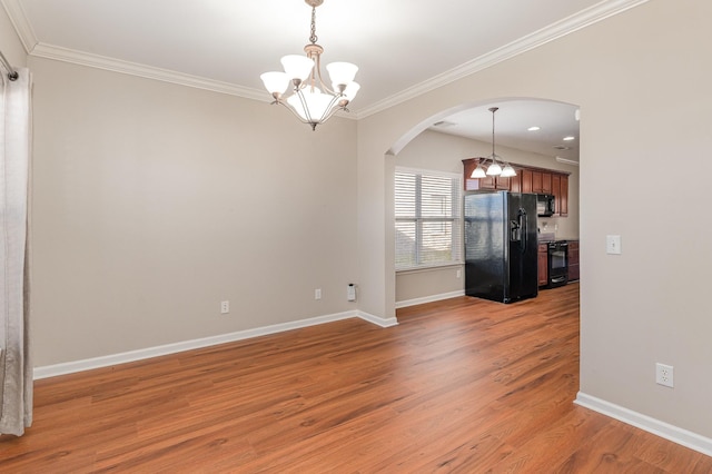 spare room featuring arched walkways, crown molding, light wood-type flooring, and an inviting chandelier