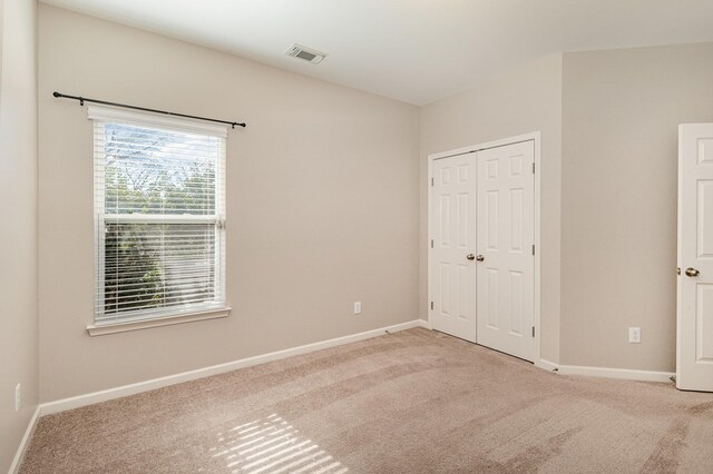 unfurnished bedroom featuring a closet, baseboards, visible vents, and carpet flooring