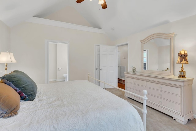 bedroom with ceiling fan, light colored carpet, vaulted ceiling, and ensuite bathroom